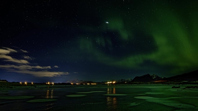 云朵从左边进入画面的夜景;在天空中追逐木星，残留的北极光像绿色的幽灵一样轻轻地漂浮在冰冻的湖面上;罗