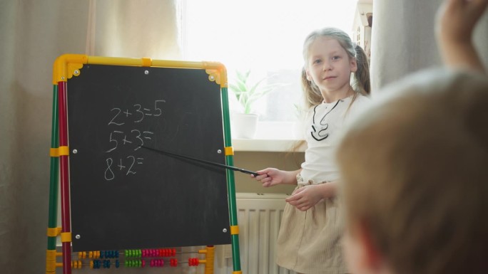 女孩让小弟弟在黑板上做数学题
