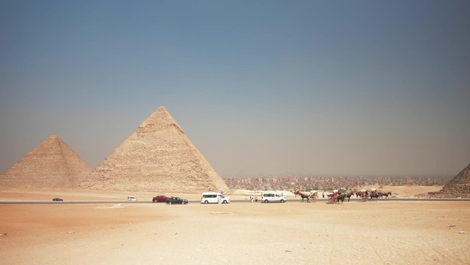 吉萨金字塔的全景，以及与游客一起游览的汽车和巴士。开罗,埃及。古代神秘的世界奇观