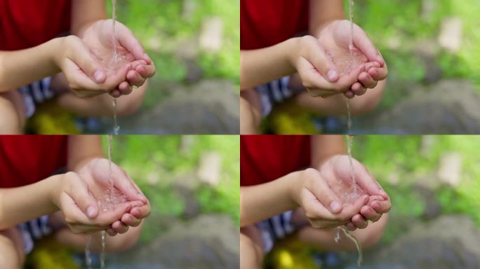 孩子的手从水龙头里接水，清澈的水从水龙头流入手中