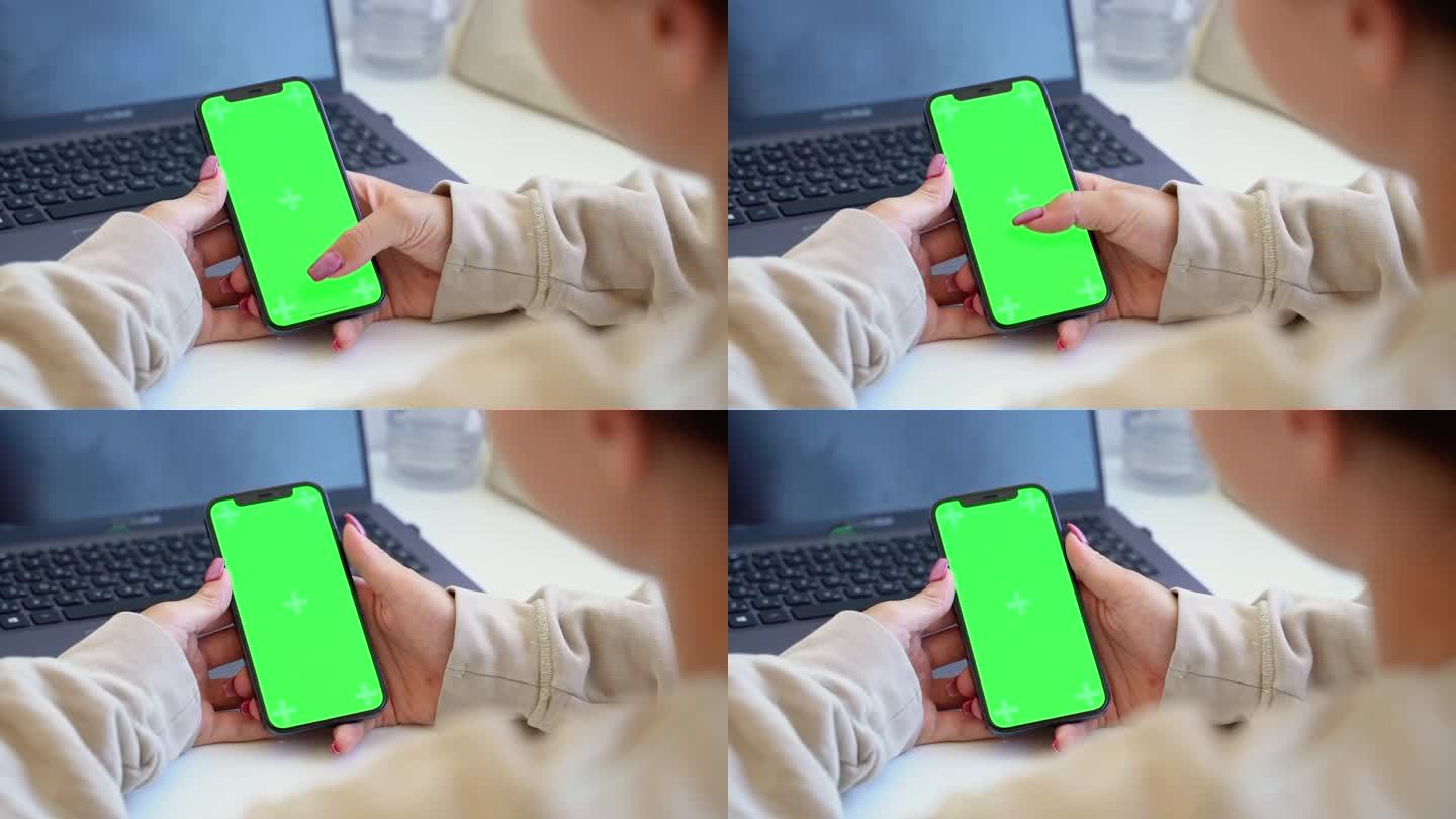 少女的手使用智能手机与空白色度键绿屏幕观看视频卷轴内容后视图