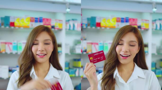 美女在药房手里拿着信用卡。