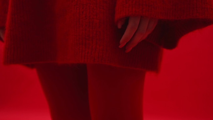手放在臀部。穿红衣服的模特女孩。艺伎在摄影棚里摆姿势