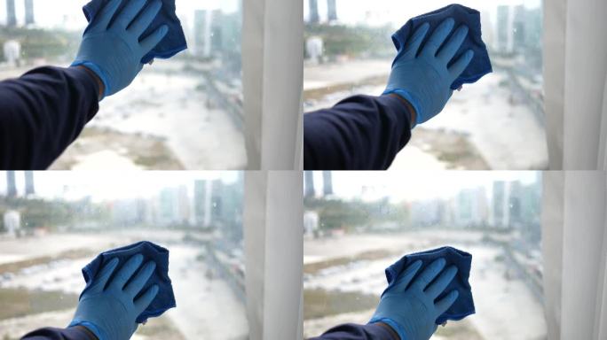 一名男子戴着手套用毛巾擦窗户玻璃的镜头