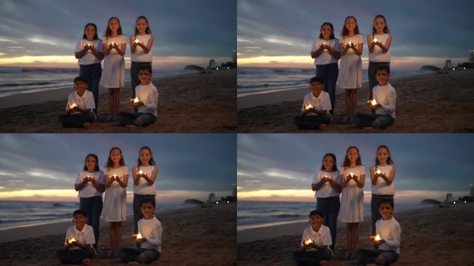 儿时朋友在沙滩上举着蜡烛的照片