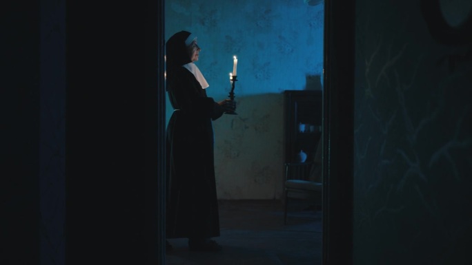 一个修女的灵魂，晚上在闹鬼的房子里，拿着燃烧的蜡烛慢慢走