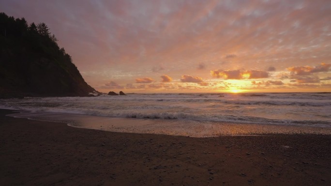 日落的天堂海滩。浪涛涌向海岸线。慢动作