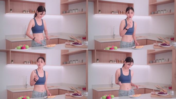 一位身着运动服的亚洲女运动员在厨房里享受着一块面包，她采用了一种平衡的体重管理方法。为了可持续的生活