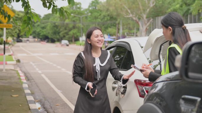 亚洲女司机与年轻女车险官员谈话同意的意外索赔将被评估和处理。