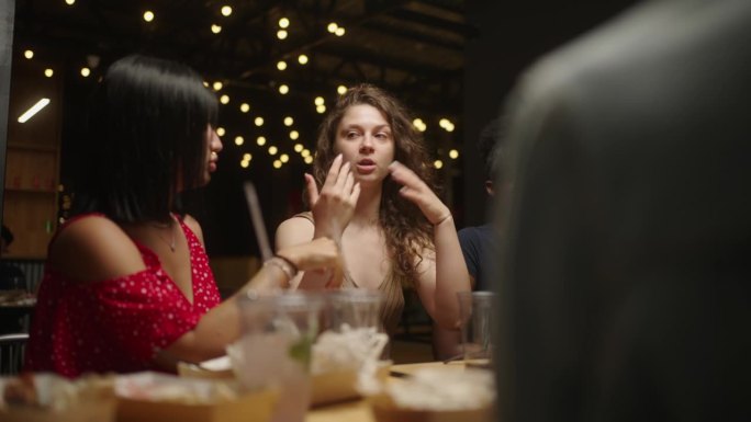 在餐厅聚会，年轻的成年女性晚上在餐厅聚会，吃饭，交流