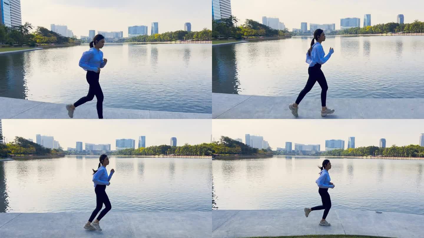 亚洲女运动员在湖边的城市跑步