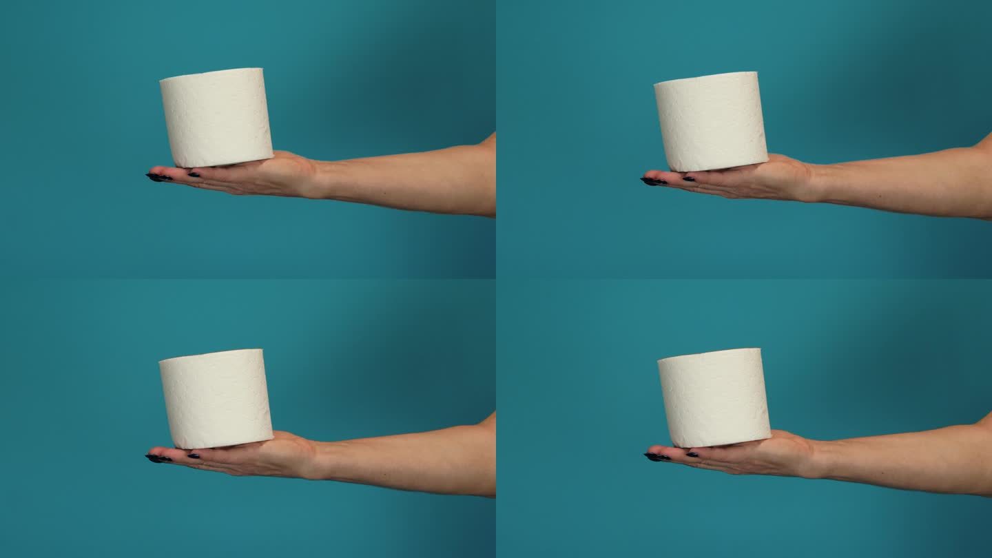一个女人用手纸的特写。手握一卷薄纸。女性手上有白色的厕纸。