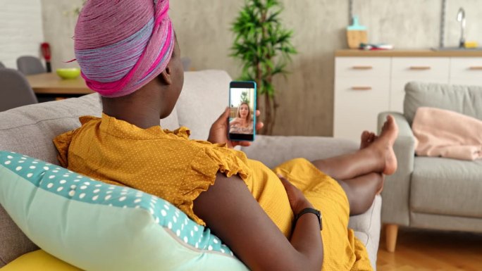 怀孕的黑人妇女在家里和朋友视频通话