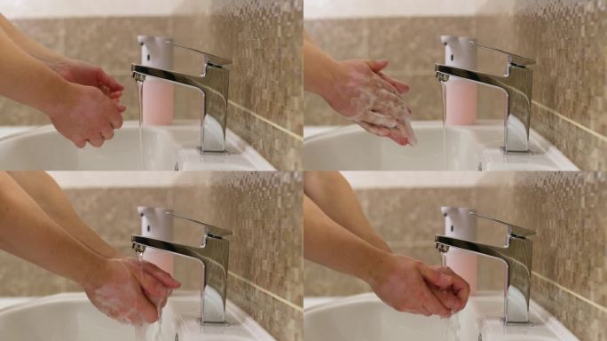 男人在浴室里用泡沫肥皂洗手。日常卫生习惯。健康的习惯