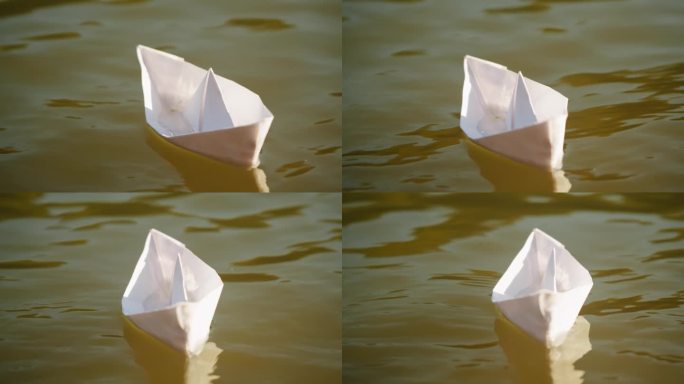 一个女人把纸船放在公园里的水上。池塘上的折纸鹤。晴天的自然湖景