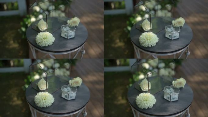 漂亮的玻璃盒子，里面装着白色的花和结婚戒指。缓慢的运动。户外婚礼庆典的婚礼装饰。