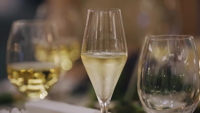 葡萄酒被倒进玻璃杯里，杯子放在漂亮的节日餐桌上。非常漂亮的特写