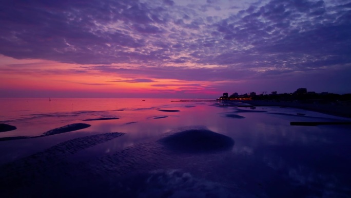 空中拍摄的沙滩在紫色的日落