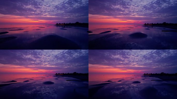 空中拍摄的沙滩在紫色的日落