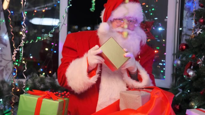 有趣的圣诞老人把漂亮的礼盒收集到红色的礼物袋里，又跳又摇
