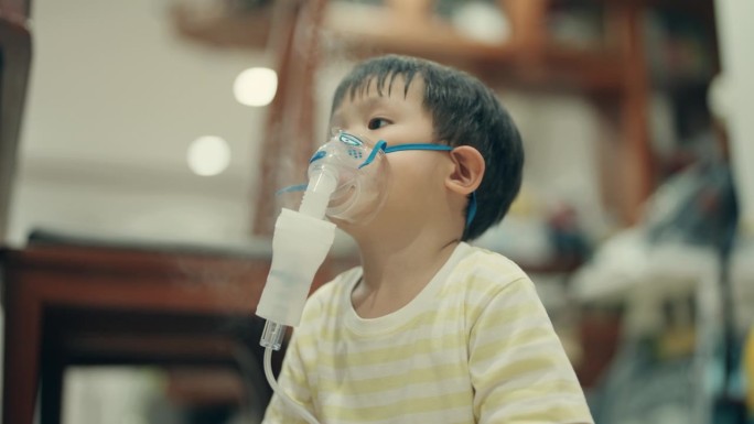 儿童保健:小亚洲男孩接受雾化吸入治疗。