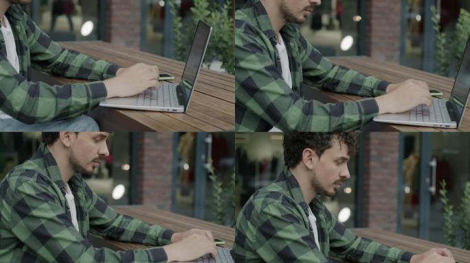 中东企业家在户外露天咖啡馆用笔记本电脑打字，忙于远方的工作