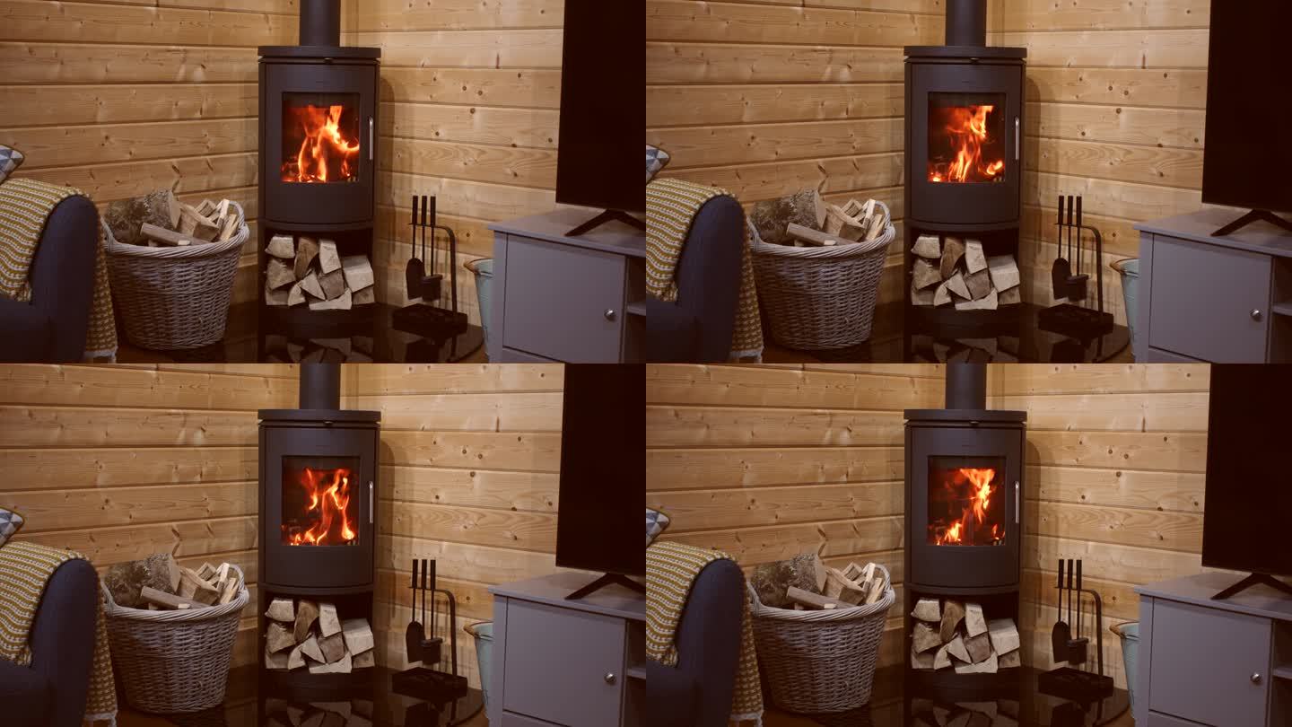 在小木屋里，有引火物和圆木的燃木炉里的火的广角镜头。
