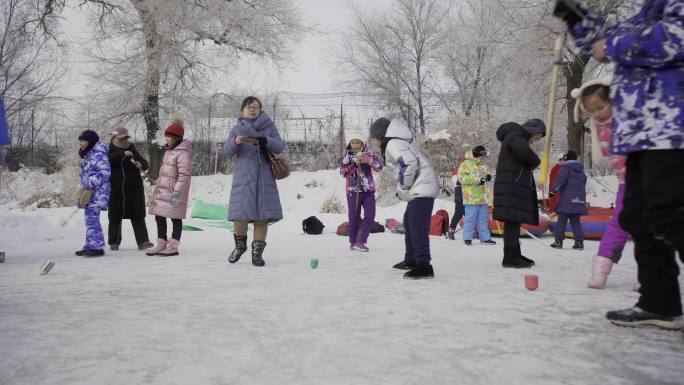 吉林雪乡雾凇岛小孩打招呼比赛冰上抽陀螺