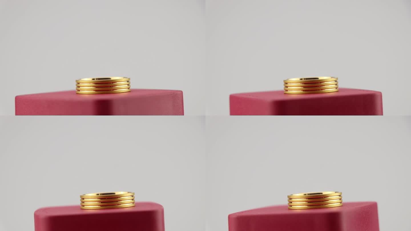 近距离观察一个由黄金制成的旋转运动的戒指。金色饰品陈列在一个红色的盒子里