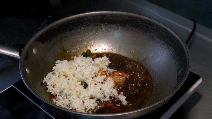 在煎锅里用虾仁和新鲜香草加酱煮米饭。