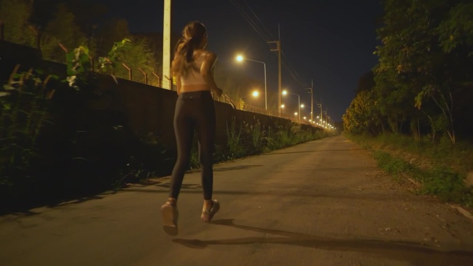 亚洲运动女子在晚上跑步。