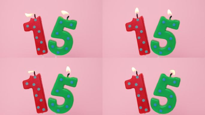 十五周年纪念视频横幅燃烧斑点红色和绿色数字十五蜡烛在浅粉红色的背景。4K分辨率生日快乐横幅