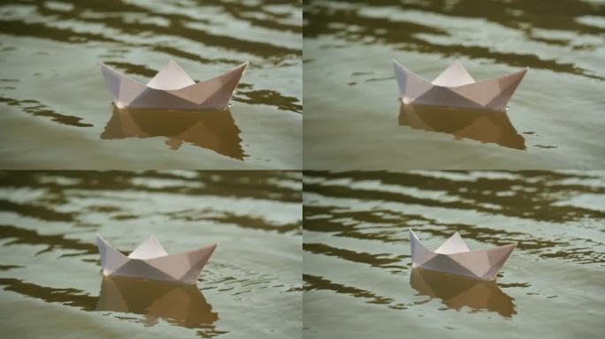 一个女人在公园里把纸船放在水面上。池塘上的折纸鹤。晴天的自然湖景