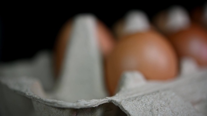 手看从右边到中间再到左边放三个鸡蛋，鸡蛋放在纸盘里，食物和烹饪。