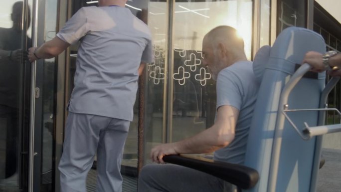 两位医生用轮椅把病人送到医院