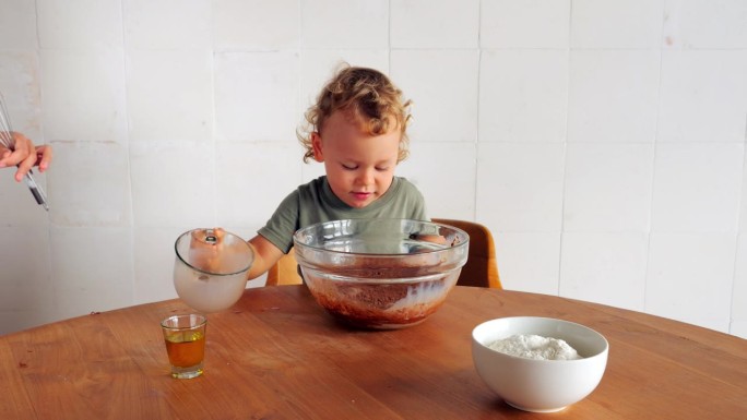 小男孩赶紧把巧克力牛奶倒进一个大碗里，做煎饼面糊