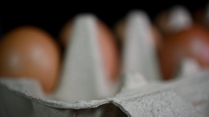 模模糊糊地看到，然后一只手看到在托盘里放了三颗鸡蛋，鸡蛋在纸托盘里，食物和烹饪。