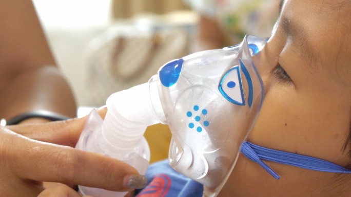 蹒跚学步的男孩在医院接受氧气喷雾器治疗。