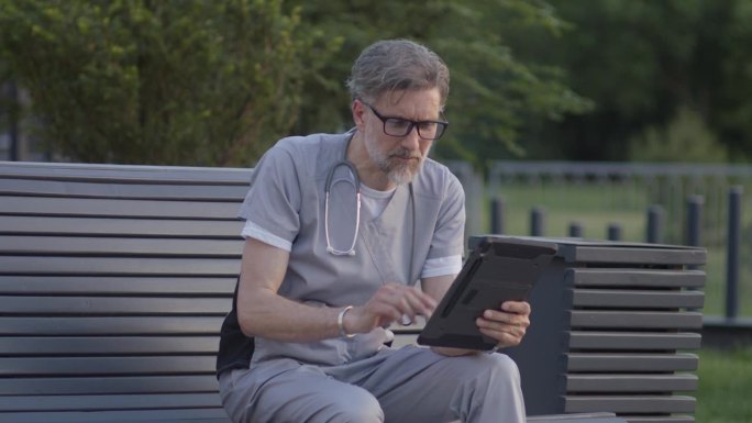 医生坐在长凳上，在网上预约时与病人交谈