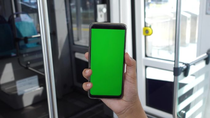 年轻人在地铁里用绿屏智能手机