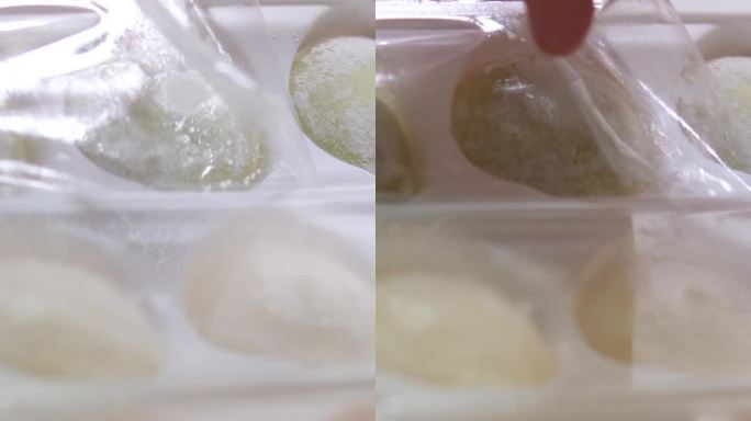 不同口味的亚洲甜点麻糬，一个女人从盒子里拿出用豌豆和大米淀粉面团做成的甜冰淇淋，放在一个白色的盘子里