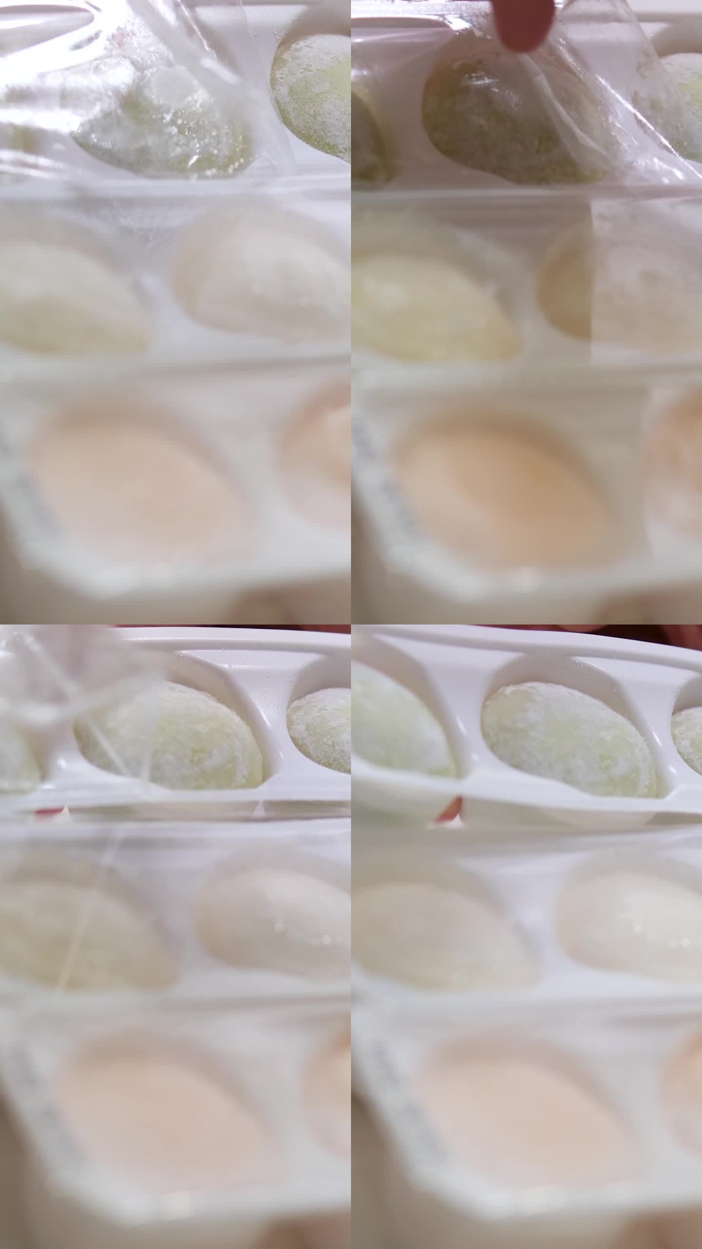 不同口味的亚洲甜点麻糬，一个女人从盒子里拿出用豌豆和大米淀粉面团做成的甜冰淇淋，放在一个白色的盘子里