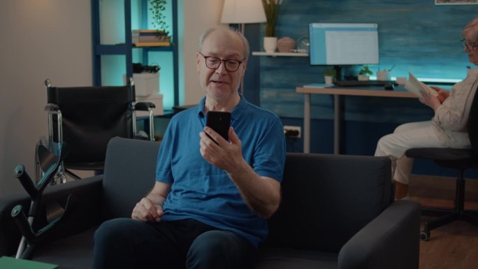 退休男子拿着智能手机和家人视频聊天