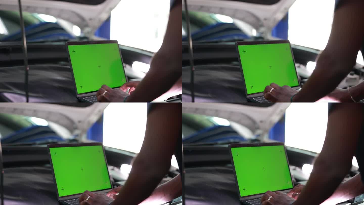 汽车维修技师女用绿屏笔记本电脑模拟色度键汽车诊断软件。汽车扫描仪计算机诊断。汽车电子诊断