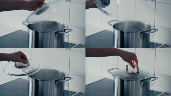 厨房炉子上沸腾着热气的大铁锅上，女人用手打开锅盖的特写慢镜头。