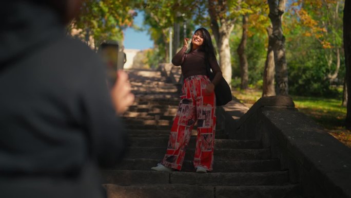女游客在古老的历史古城公园用智能手机拍摄多民族女游客朋友的照片和视频