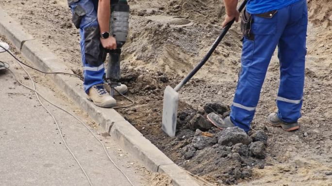 道路工程地盘承建商用铁铲及风锤更换混凝土路沿砖