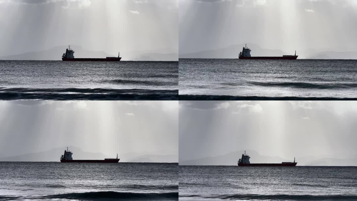 货船在暴风雨的天气里停泊在海上，光线从云层中照在它身上，阴晴不定