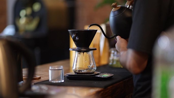 咖啡师通过将溢出的热水倒在咖啡粉上来制作滴漏咖啡