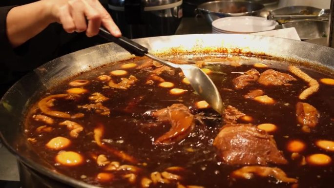 手拿勺子搅拌和混合肉和鸡蛋在这浓汤称为凯帕洛蛋和猪肉中国风格，接受泰国食品，曼谷，泰国